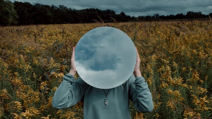 person in red and black long sleeve shirt holding white round ball