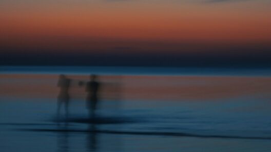 A couple of people standing on top of a beach